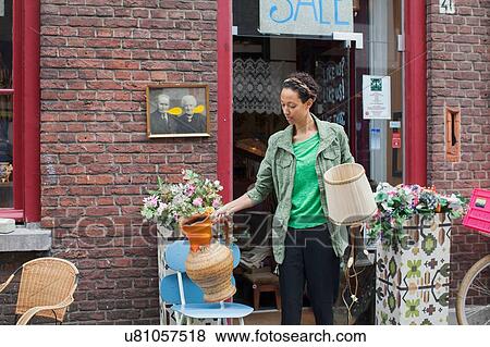 Female customer with jug and lamp outside vintage shop View Large Photo Image Stock Photo - Female customer with jug and lamp outside vintage shop. Fotosearch