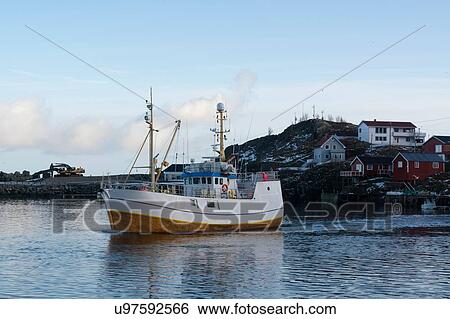 Stock Photograph - Fishing boat leaving harbour, Hamnoy, Lofoten Islands, Norway. Fotosearch