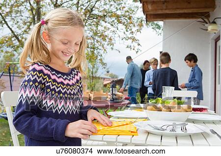 Girl folding napkins at garden barbecue table View Large Photo Image Picture - Girl folding napkins at garden barbecue table. Fotosearch