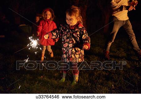 Girls holding sparklers smiling View Large Photo Image Stock Photograph - Girls holding sparklers smiling. Fotosearch