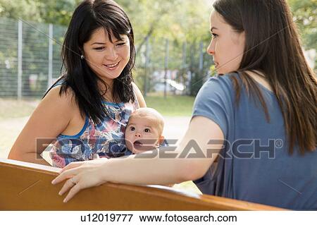 Grandmother sitting on park bench with daughter and baby granddaughter View Large Photo Image Stock Photo - Grandmother sitting on park bench with daughter and baby granddaughter. Fotosearch