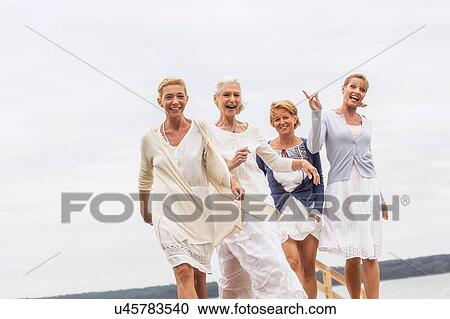 Group of female friends, walking outdoors, laughing View Large Photo Image Stock Image - Group of female friends, walking outdoors, laughing. Fotosearch