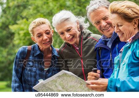 Group of friends, hiking, looking at map View Large Photo Image Stock Photo - Group of friends, hiking, looking at map. Fotosearch