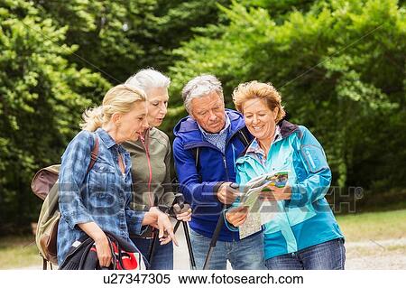 Group of friends, hiking, looking at map View Large Photo Image Stock Photography - Group of friends, hiking, looking at map. Fotosearch