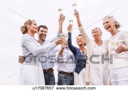 Group of friends holding wine glasses, raising glasses in toast View Large Photo Image Stock Photo - Group of friends holding wine glasses, raising glasses in toast. Fotosearch