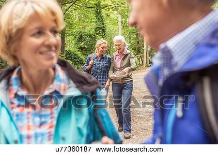 Stock Photo - Group of friends on hiking trail, looking at map. Fotosearch