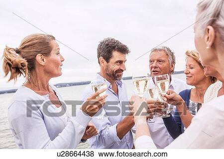 Group of friends raising wine glasses, making toast View Large Photo Image Stock Photo - Group of friends raising wine glasses, making toast. Fotosearch