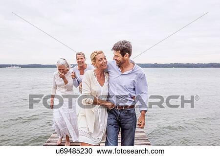 Group of friends walking on pier View Large Photo Image Stock Image - Group of friends walking on pier. Fotosearch