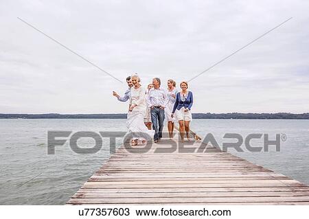 Group of friends walking on pier View Large Photo Image Stock Image - Group of friends walking on pier. Fotosearch