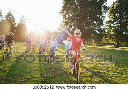 Group of partygoing adults arriving on cycles to sunset park party View Large Photo Image Stock Image - Group of partygoing adults arriving on cycles to sunset park party. Fotosearch