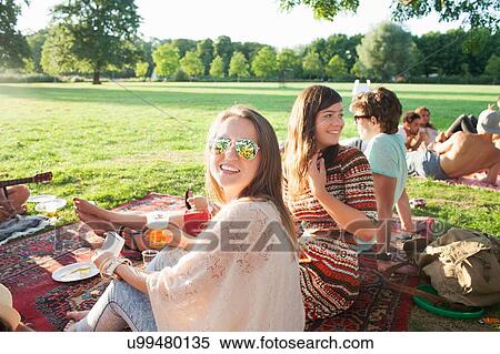 Happy young woman and friends at sunset park party View Large Photo Image Stock Photography - Happy young woman and friends at sunset park party. Fotosearch