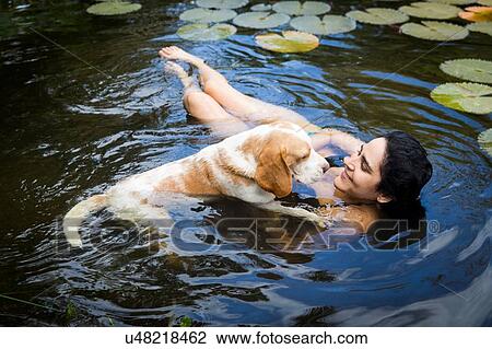 High angle view of young woman with dog floating among lily pads smiling, Taiba, Ceara, Brazil View Large Photo Image Stock Image - High angle view of young woman with dog floating among lily pads smiling, Taiba, Ceara, Brazil. Fotosearch