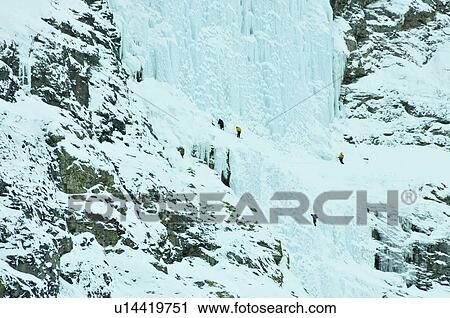 Stock Image - Ice climbers preparing to scale the weeping wall, frozen waterfall, Canmore, Canada. Fotosearch