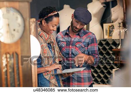 Male customer checking digital tablet online in vintage shop View Large Photo Image Stock Photography - Male customer checking digital tablet online in vintage shop. Fotosearch