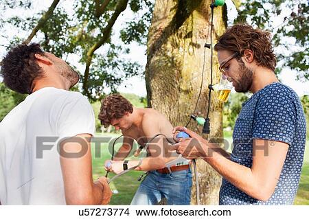 Male friends preparing decorative lights for park party View Large Photo Image Picture - Male friends preparing decorative lights for park party. Fotosearch