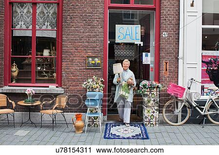 Mature female customer carrying lamp outside vintage shop View Large Photo Image Stock Image - Mature female customer carrying lamp outside vintage shop. Fotosearch