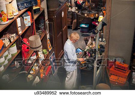 Mature woman stocktaking with digital tablet in vintage shop View Large Photo Image Stock Image - Mature woman stocktaking with digital tablet in vintage shop. Fotosearch