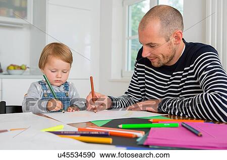 Mid adult man and toddler daughter drawing at kitchen table View Large Photo Image Stock Image - Mid adult man and toddler daughter drawing at kitchen table. Fotosearch