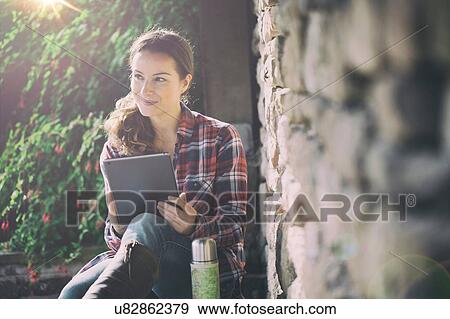 Mid adult woman using digital tablet in gardens at Thornbury Castle, South Gloucestershire, UK View Large Photo Image Stock Photo - Mid adult woman using digital tablet in gardens at Thornbury Castle, South Gloucestershire, UK. Fotosearch
