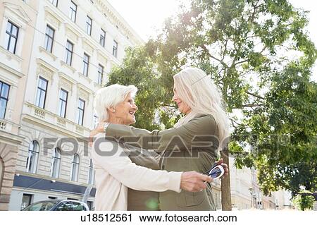 Mother and daughter hugging in street, smiling View Large Photo Image Stock Image - Mother and daughter hugging in street, smiling. Fotosearch
