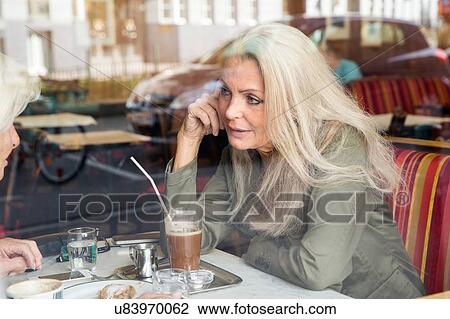 Mother and daughter sitting together in cafe, seen through cafe window View Large Photo Image Stock Image - Mother and daughter sitting together in cafe, seen through cafe window. Fotosearch