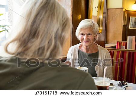 Mother and daughter sitting together in cafe View Large Photo Image Stock Photo - Mother and daughter sitting together in cafe. Fotosearch