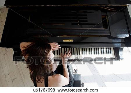 Overhead view of mature woman leaning on piano playing View Large Photo Image Stock Photo - Overhead view of mature woman leaning on piano playing. Fotosearch