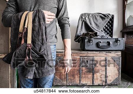 Picture - Photographer preparing for trip, mid section. Fotosearch