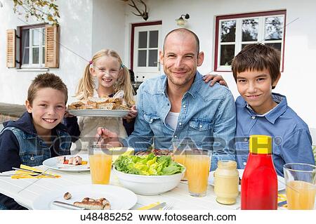 Portrait of father and three children at garden barbecue table View Large Photo Image Stock Image - Portrait of father and three children at garden barbecue table. Fotosearch