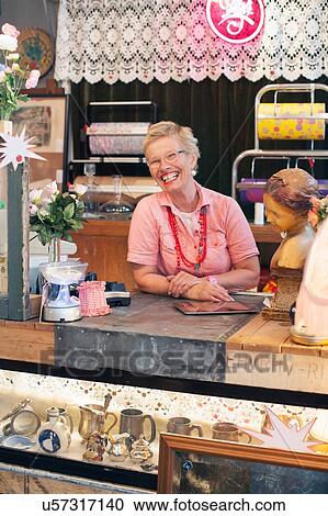 Portrait of happy mature woman behind vintage shop counter View Large Photo Image Stock Image - Portrait of happy mature woman behind vintage shop counter. Fotosearch