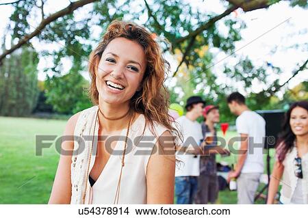 Picture - Portrait of happy young woman at sunset party in park. Fotosearch