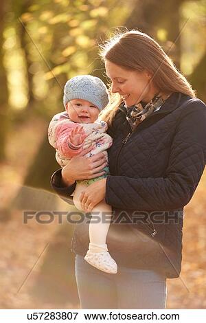 Portrait of mid adult woman and baby daughter in autumn park View Large Photo Image Stock Photo - Portrait of mid adult woman and baby daughter in autumn park. Fotosearch