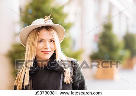 Stock Image - Portrait of stylish young woman wearing felt hat, Covent Garden, London, UK. Fotosearch
