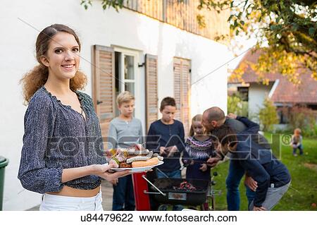 Portrait of teenage girl carrying plate of barbecued food at garden barbecue View Large Photo Image Stock Image - Portrait of teenage girl carrying plate of barbecued food at garden barbecue. Fotosearch