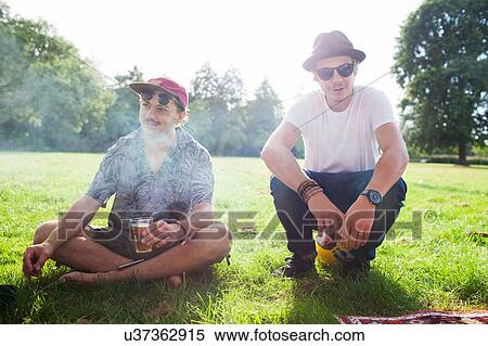 Stock Photography - Portrait of two cool male friends at park party. Fotosearch