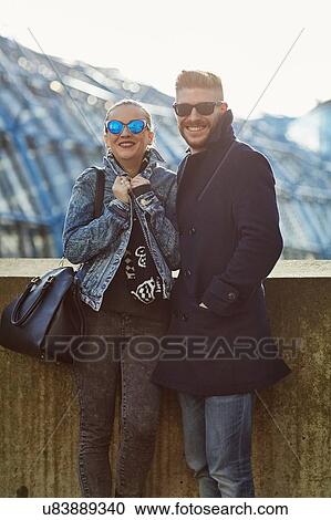 Portrait of young couple outdoors, wearing sunglasses View Large Photo Image Stock Image - Portrait of young couple outdoors, wearing sunglasses. Fotosearch