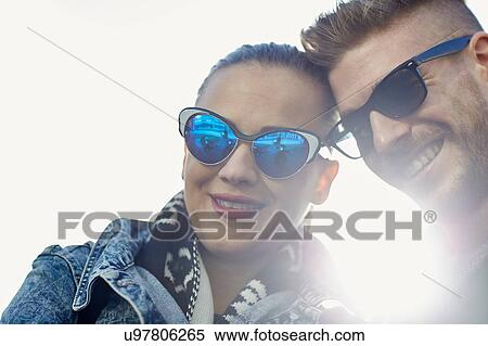 Stock Photography - Portrait of young couple wearing sunglasses, outdoors. Fotosearch