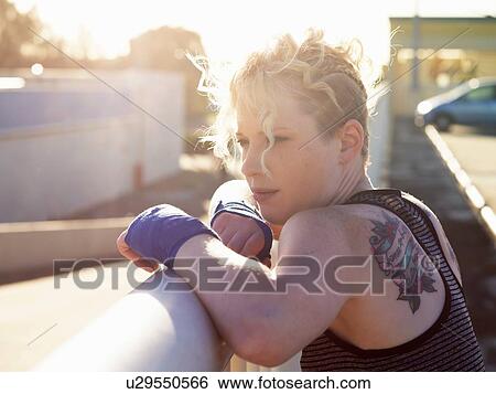 Portrait of young female boxer leaning against urban railing View Large Photo Image Stock Photograph - Portrait of young female boxer leaning against urban railing. Fotosearch