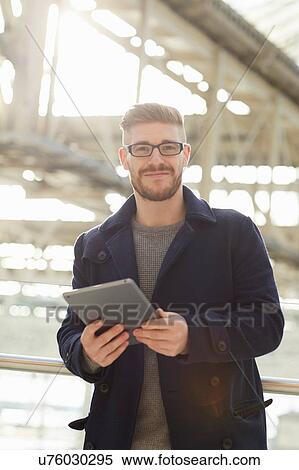 Portrait of young man, holding digital tablet, outdoors View Large Photo Image Stock Photography - Portrait of young man, holding digital tablet, outdoors. Fotosearch