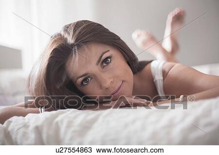 Portrait of young woman, relaxing on bed View Large Photo Image Stock Image - Portrait of young woman, relaxing on bed. Fotosearch