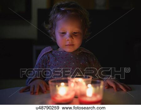 Preschool girl hands on table looking down at burning candles View Large Photo Image Stock Photo - Preschool girl hands on table looking down at burning candles. Fotosearch