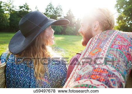 Rear view of romantic young couple carrying rug for picnic in park View Large Photo Image Stock Photo - Rear view of romantic young couple carrying rug for picnic in park. Fotosearch