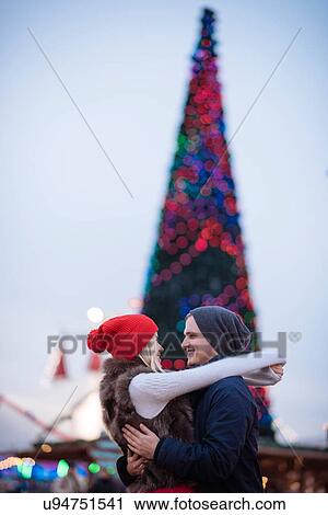 Stock Image - Romantic young couple hugging at xmas festival in Hyde Park, London, UK. Fotosearch