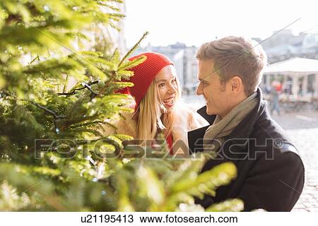 Romantic young couple next to xmas tree in Covent Garden, London, UK View Large Photo Image Stock Image - Romantic young couple next to xmas tree in Covent Garden, London, UK. Fotosearch