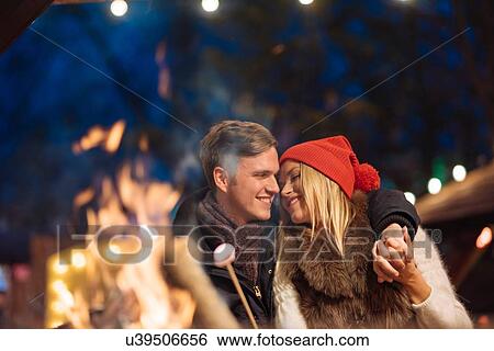Romantic young couple toasting marshmallows at xmas festival in Hyde Park, London, UK View Large Photo Image Stock Photograph - Romantic young couple toasting marshmallows at xmas festival in Hyde Park, London, UK. Fotosearch