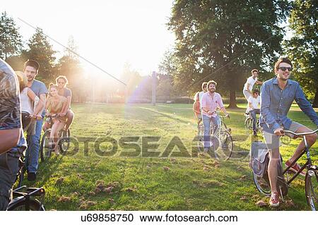 Rows of party going adults arriving in park on bicycles at sunset View Large Photo Image Stock Image - Rows of party going adults arriving in park on bicycles at sunset. Fotosearch