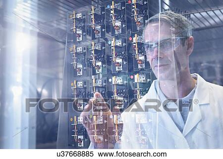 Stock Photography - Scientist inspecting test lithium ion batteries in heat chamber in battery research facility. Fotosearch