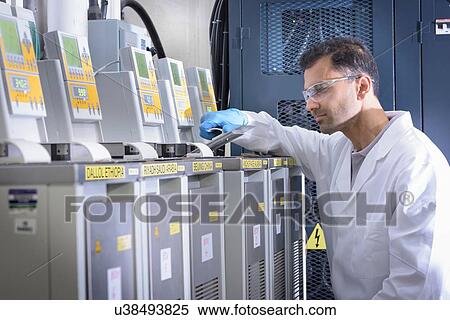 Stock Photography - Scientist with lithium ion battery aging equipment in battery research facility. Fotosearch