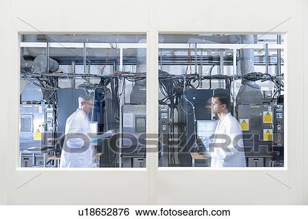 Stock Photograph - Scientists in lithium ion battery test facility in battery research facility. Fotosearch