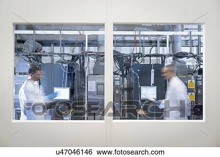 Stock Photograph - Scientists in lithium ion battery test facility in battery research facility. Fotosearch